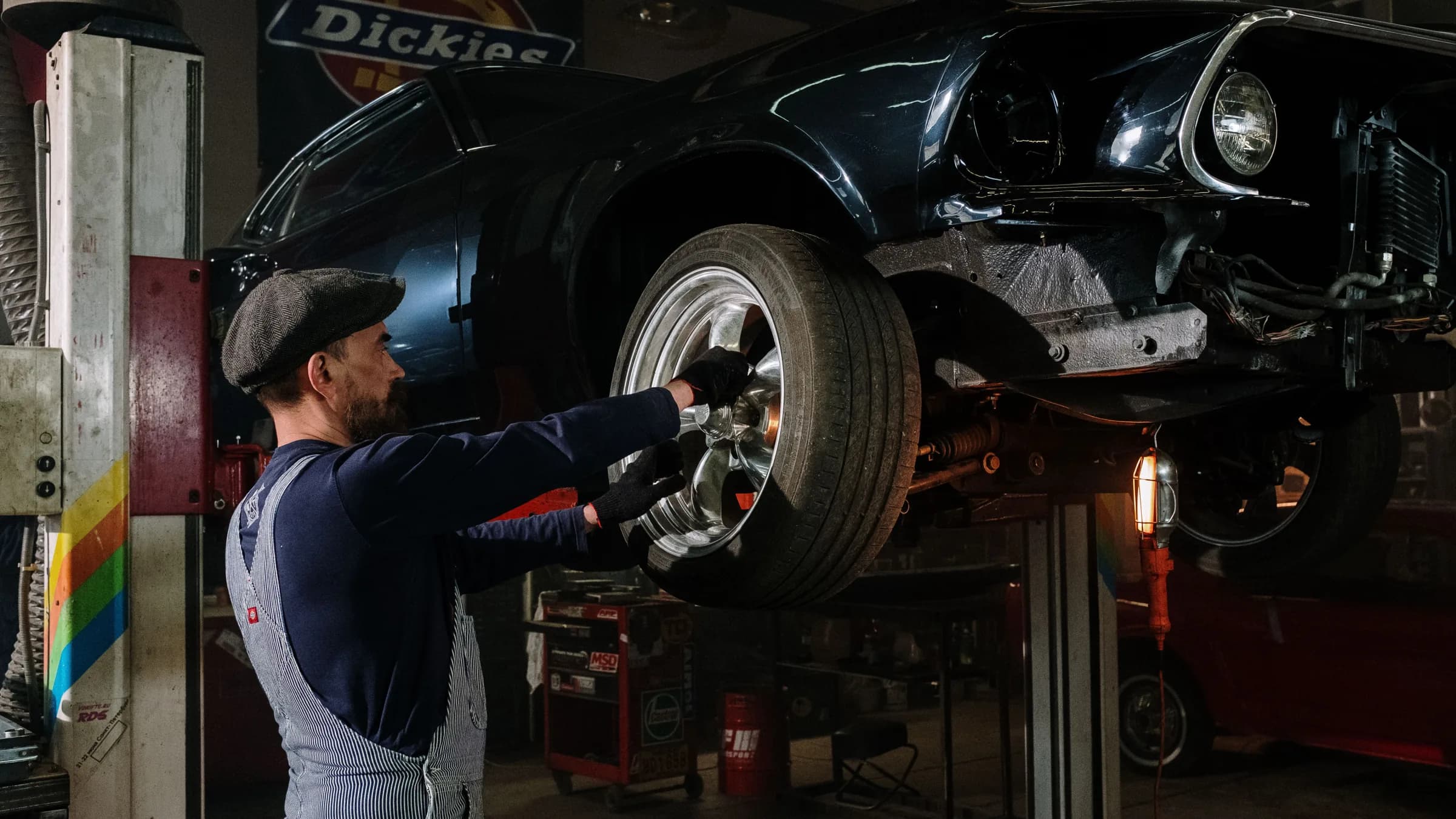 Mechaniker arbeitet am Vorderrad eines Fahrzeugs auf der Hebebühne